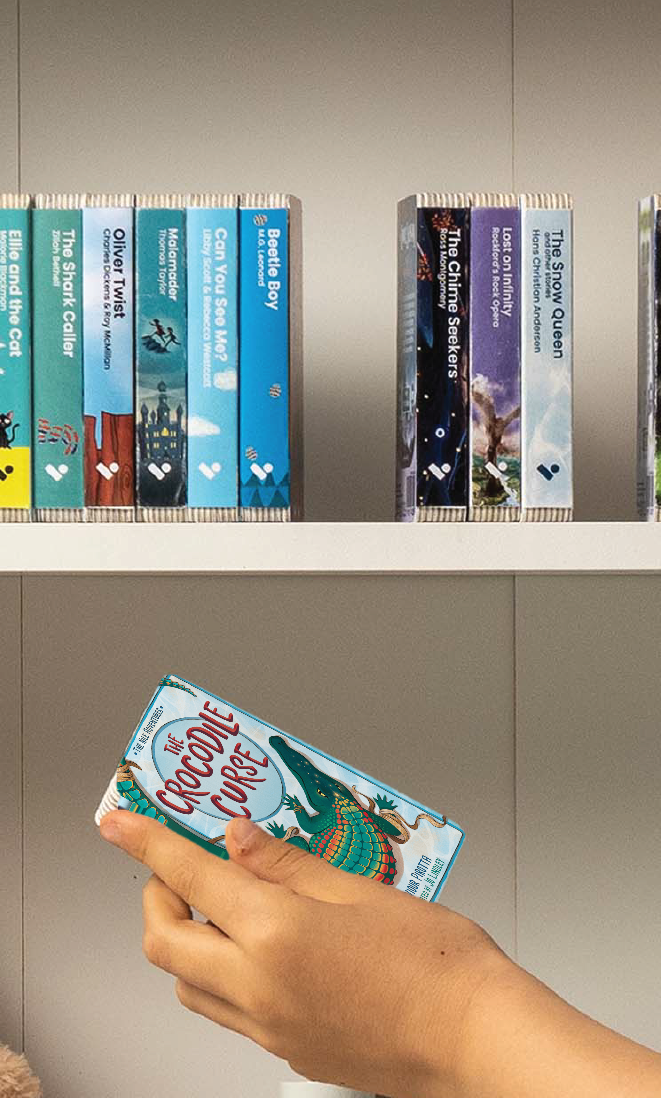 A hand taking The Crocodile Curse audiobook from a shelf of Voxblock audiobooks