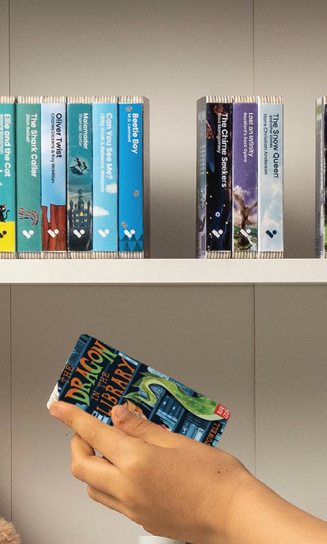 A hand taking The Dragon in the Library audiobook from a shelf of Voxblock audiobooks