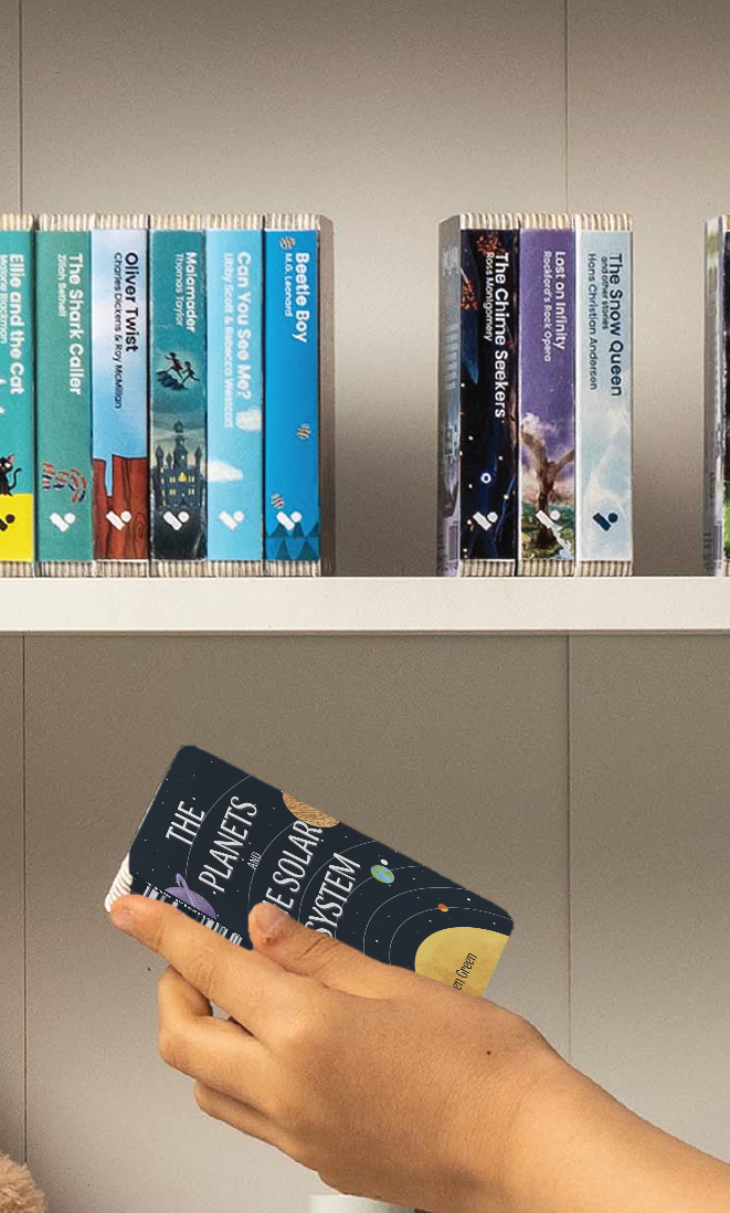 A hand taking The Planets and The Solar System audiobook from a shelf of Voxblock audiobooks