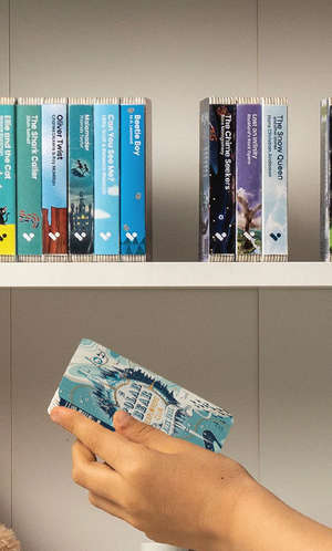 A hand taking The Polar Bear Explorers' Club audiobook from a shelf of Voxblock audiobooks