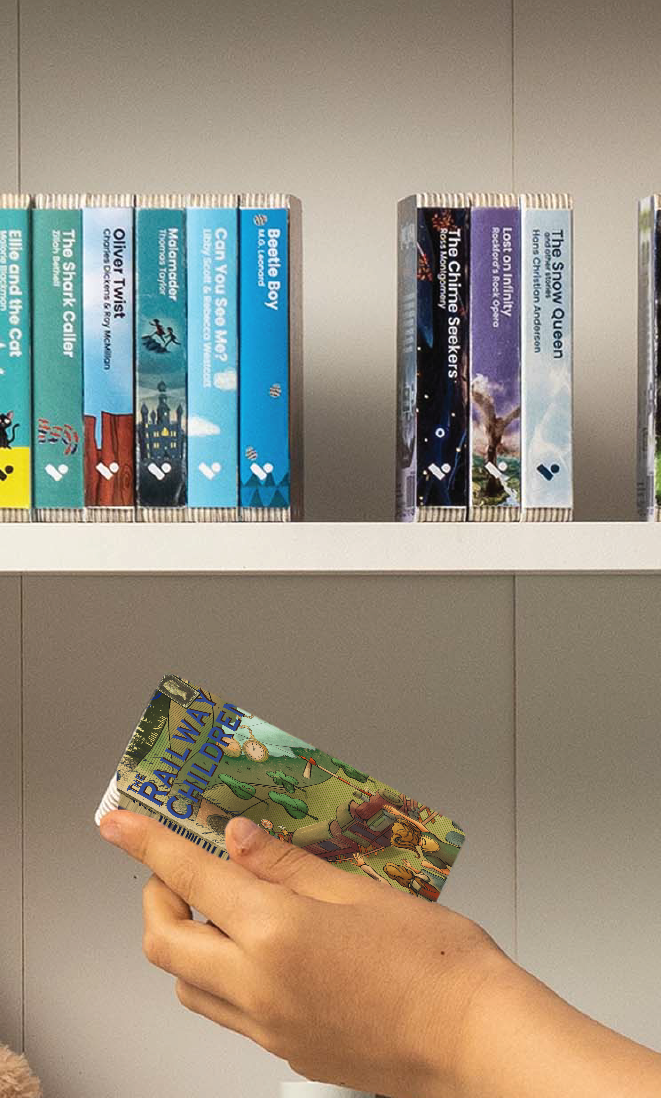 A hand taking The Railway Children audiobook from a shelf of Voxblock audiobooks