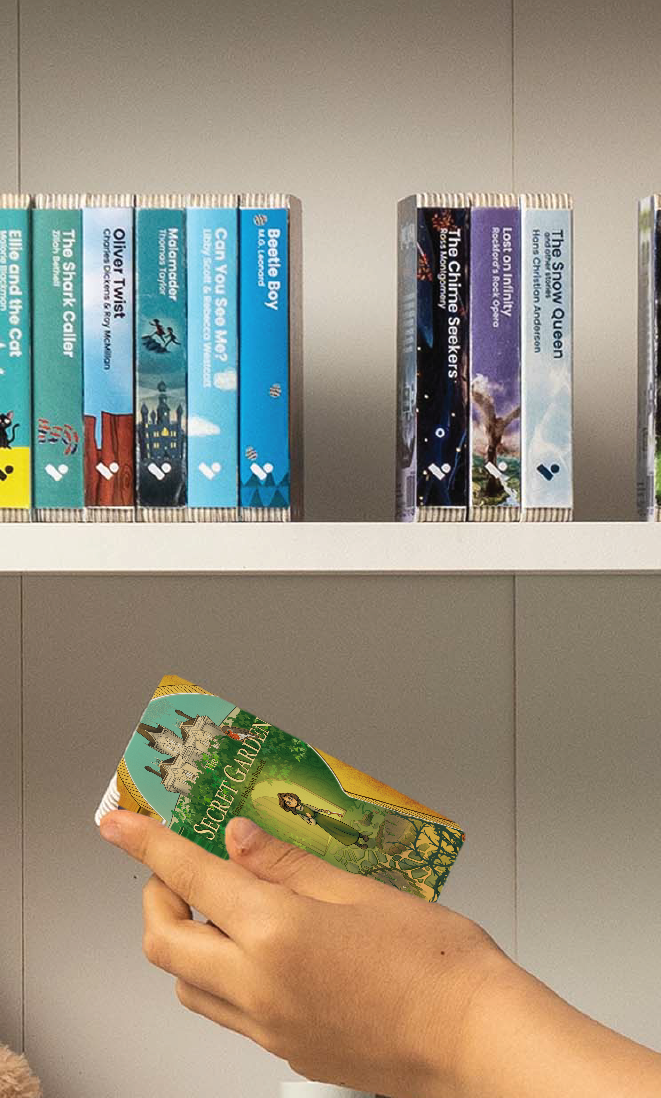 A hand taking The Secret Garden audiobook from a shelf of Voxblock audiobooks