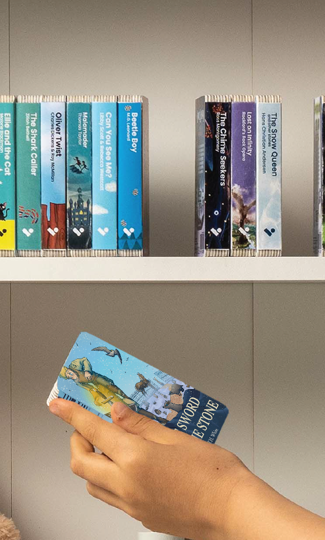 A hand taking The Sword in the Stone audiobook from a shelf of Voxblock audiobooks