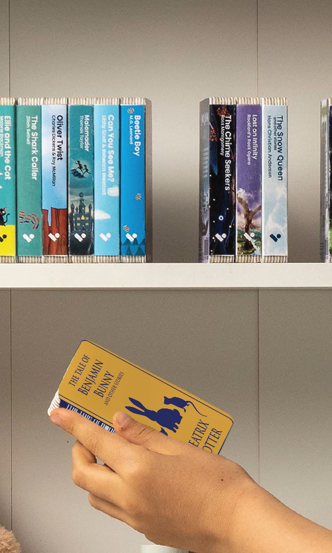 A hand taking The Tale of Benjamin Bunny and Other Stories audiobook from a shelf of Voxblock audiobooks