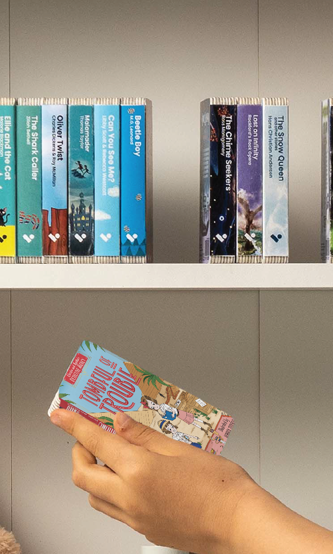 A hand taking the Tombful of Trouble audiobook from a shelf of Voxblock audiobooks