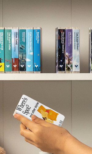 A hand taking the Where's Spot? and Other Stories audiobook from a shelf of Voxblock audiobooks