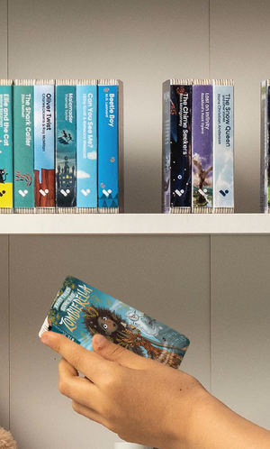 A hand taking the Zombierella audiobook from a shelf of Voxblock audiobooks